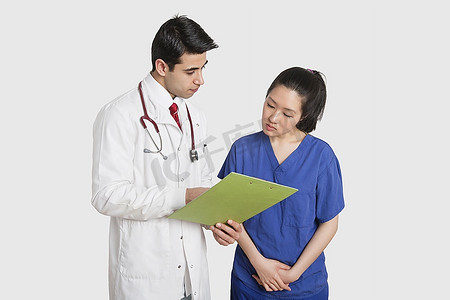 医生讨论医疗报告与女护士在灰色背景