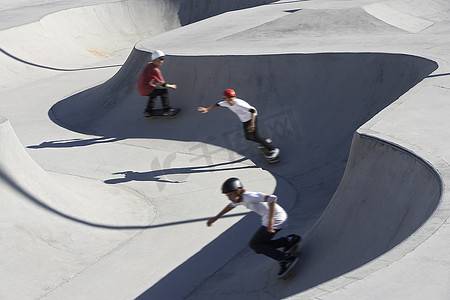 三个十几岁的男孩(16-17岁)在溜冰公园滑板，俯瞰