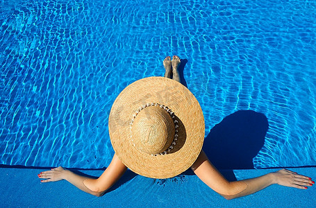 妇女在帽子放松在游泳池