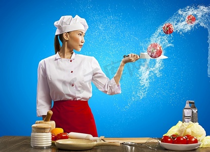 亚洲女厨师在空中用刀切水果和蔬菜