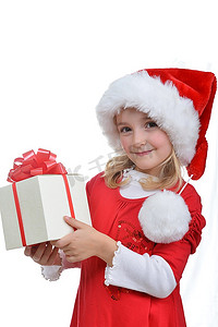 戴着红色圣诞帽的小女孩拿着圣诞礼物