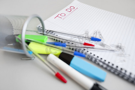 线圈笔记本与待办事项列表和办公用品的特写视图