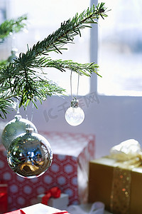 圣诞树上的装饰品与背景礼物的特写