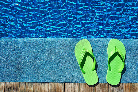 屈原鞋子摄影照片_游泳池边的绿色拖鞋