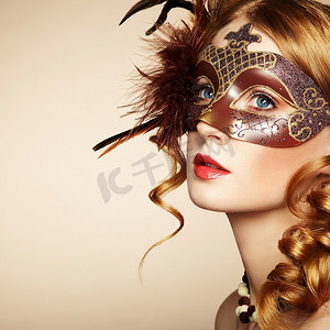 一位戴着棕色神秘威尼斯面具的年轻漂亮女子。时尚写真
