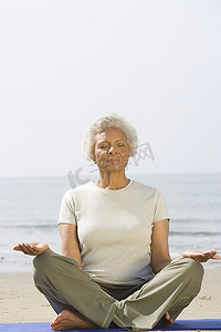 一位资深女性以瑜伽姿势盘腿坐着