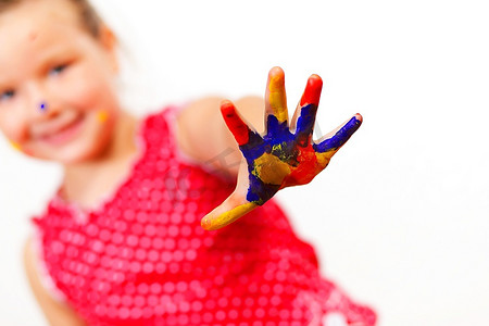 小孩子的手被涂上了五颜六色的油漆，准备留下手印