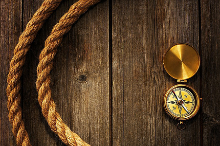 古董黄铜指南针和绳子在木背景