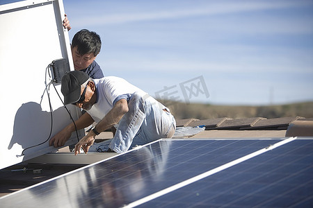 两个人在屋顶上做太阳能板