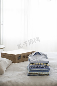 卧室摄影照片_在手提箱旁熨烫和折叠的衬衫