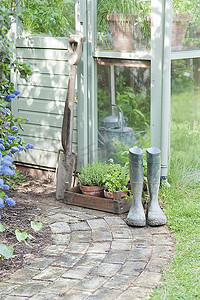 温室外的园艺工具和惠灵顿靴子