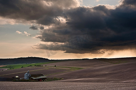 美丽的风景在农业领域与忧郁的天空和令人振奋的阳光