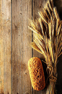 小黑麦摄影照片_木质背景上的黑麦小穗和面包