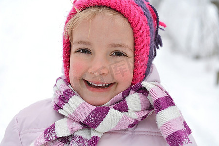 下雪玩耍摄影照片_小女孩在寒冷和下雪的户外玩耍