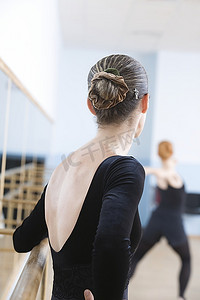 芭蕾舞排练室里，一名年轻女子站在吧台前