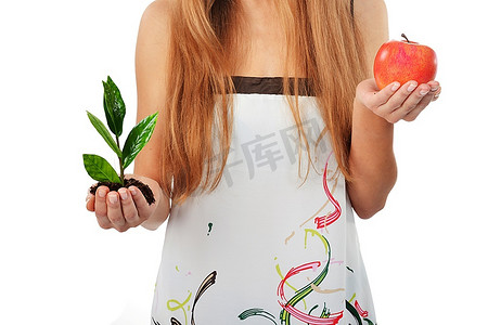 美丽的年轻女子抱着绿色的树芽和苹果