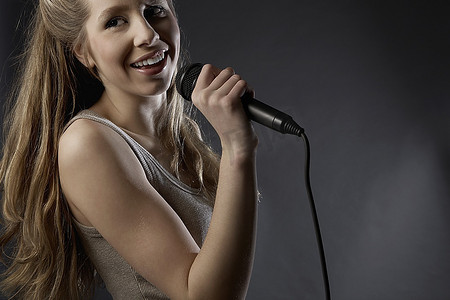 一名年轻女子在录音棚里唱歌，特写