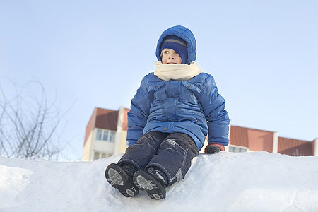 坐在雪地里的小男孩