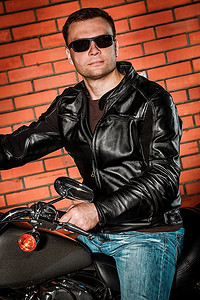 骑摩托车的人戴着墨镜，穿着皮夹克