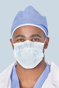 特写镜头的一名男外科医生戴面具在浅蓝色背景