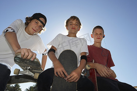 三个十几岁的男孩（16-17）与滑板，户外，肖像