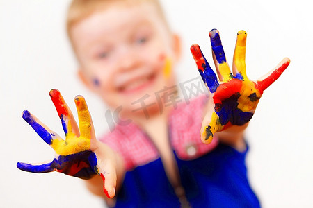 小孩子画画摄影照片_小孩子的手被涂上了五颜六色的油漆，准备留下手印