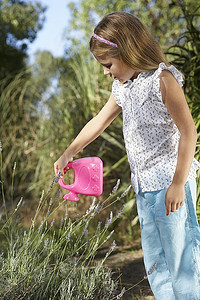 女孩（5-6）浇水植物与塑料罐