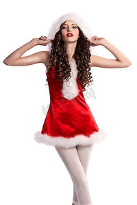 十几岁的黑发女郎，留着长卷发，穿着带帽子的圣诞老人短衣橱，涂着红色口红