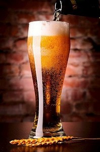 桌子上的一杯啤酒靠在砖墙上