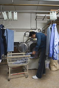 男子将衣服装入洗衣机