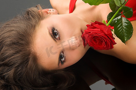 一位戴着红玫瑰的黑发美女的黑色肖像
