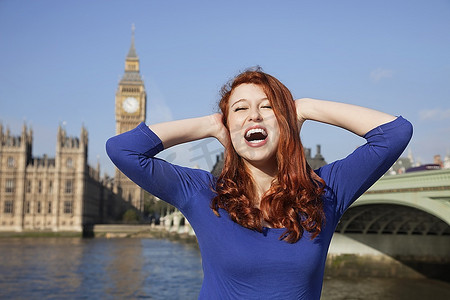 英国伦敦大本钟摄影照片_愤怒的年轻女子手牵着头尖叫着反对英国伦敦大本钟钟楼