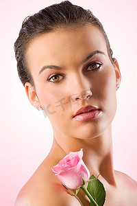 一位戴着粉色玫瑰的黑发美女的特写肖像