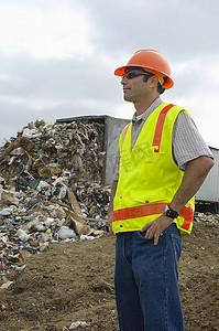 萌萌的卡通脸摄影照片_工人站在附近的卡车倾倒废物在垃圾填埋场