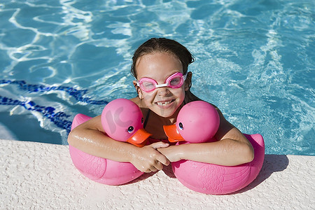 池边的女孩抱着粉红色的橡皮鸭