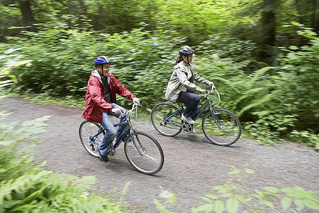 森林骑车摄影照片_两个人在森林里骑车，俯瞰，运动模糊