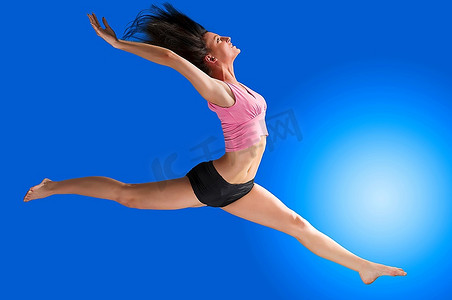 一名可爱的体操运动员，在蓝色背景下跳跃