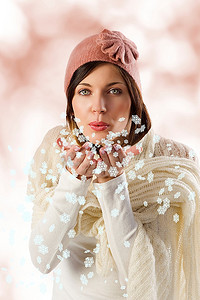 戴着白色围巾，戴着一顶粉色冬帽的可爱漂亮女孩在雪花上飘扬