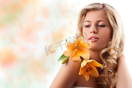 年轻美丽的金发女孩的经典美人肖像，橙色百合，金色卷发覆盖白色