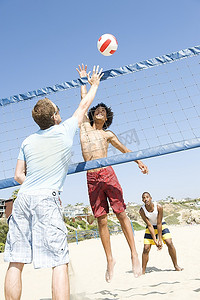 年轻男子摄影照片_打沙滩排球的年轻男子
