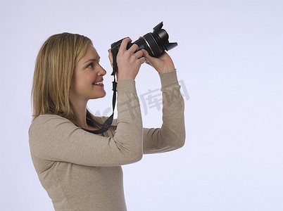 年轻(20-25岁)女摄影师,手持相机,工作室拍摄卡通动漫人物人物特写