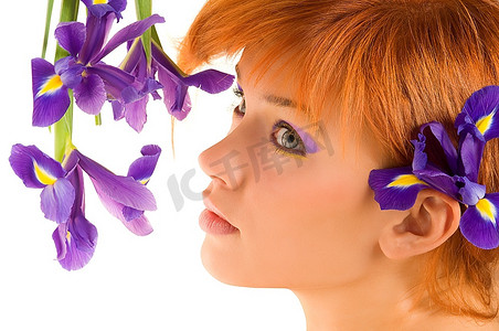 漂亮的年轻红发躺在紫罗兰花旁的新鲜肖像