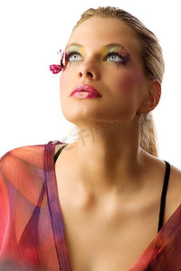 美女睫毛摄影照片_一位化妆创意的金发美女，脸上带着蝴蝶，抬头看着