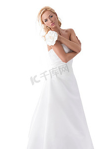美丽的金发女孩戴着新娘的面纱，手边有花卉装饰。在白色背景上隔离