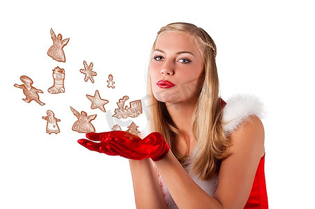 圣诞老人红色连衣裙的漂亮和性感的金发女郎女孩摆出一个微笑与一个不错的发型吹饼干