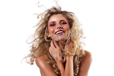 一位笑着卷曲的金发女郎在风中挥舞头发的面部照片