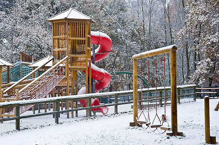 空虚的孩子和敏锐的；白雪覆盖的公园里的S游乐场，到处都是初雪