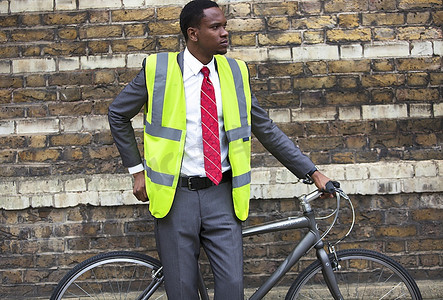 穿着安全背心骑着自行车的非裔美国商人肖像