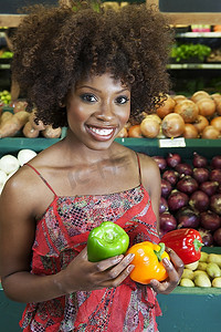 c超市摄影照片_一名非裔美国妇女在超市里拿着甜椒