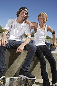 两个十几岁的男孩(16-17岁)在溜冰公园玩滑板，肖像